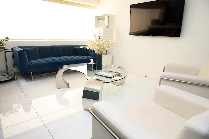 Bright patient lounge with a blue velvet sofa